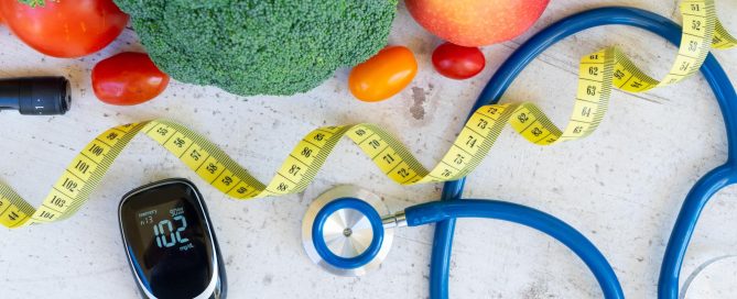 Healthy food like broccoli apple lemon tomato with stethoscope, insulin monitor, and tape measure